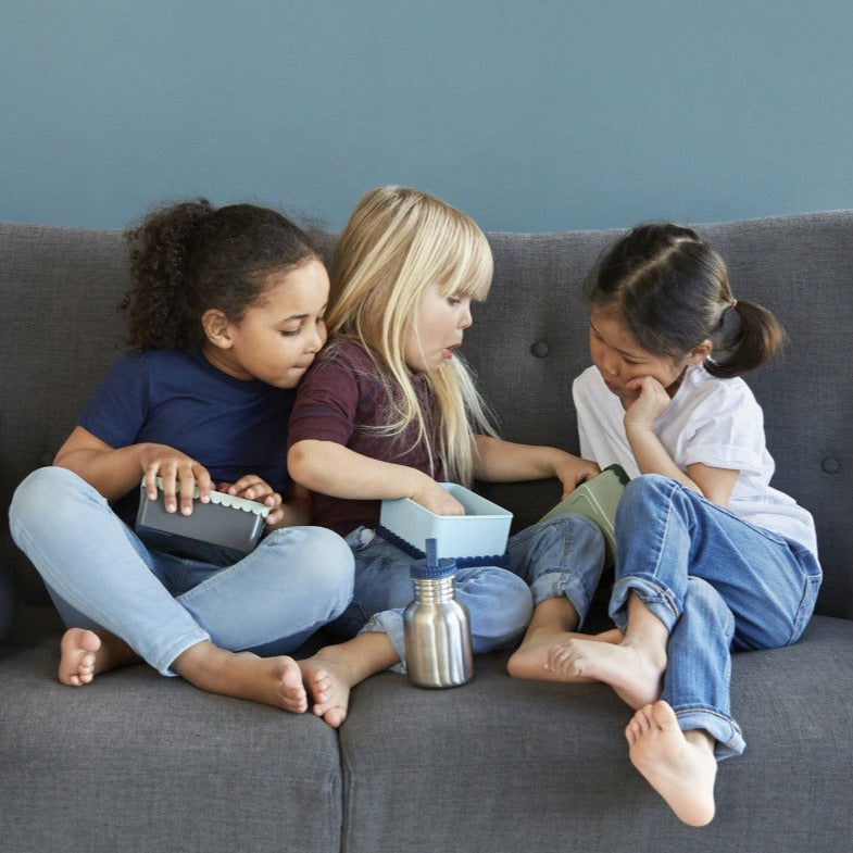 Tre jenter sitter på sofa med Blafre matbokser - Snetind